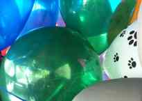 bunch of colorful balloons smashed together. Hint of a car seat below them.