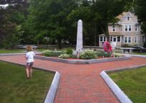 A young girl runs across the field in front of a mini-Washington monument.