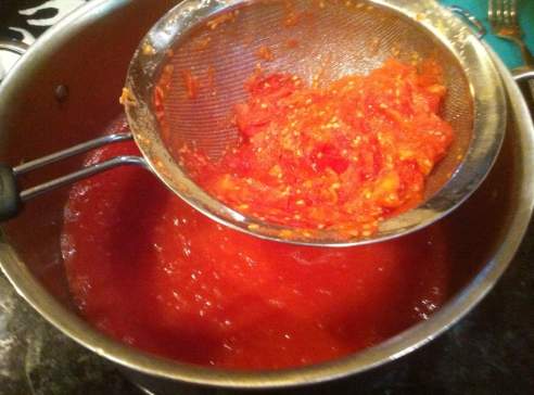 StrainThruMesh copy still bright red, the tomatoes are strained through a colander with a fine wire mesh