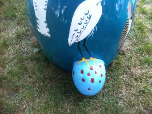 TailSmaller From the back, you can see the legs of a giant white bird (but not its head) standing on Not So Silent Spring's speckled tail.