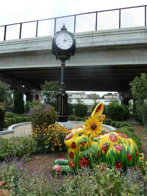 This photo shows Lady Bugs Bunny sitting in a small garden under the overpass at Dedham Crossing in Dedham Massachusetts.