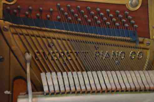 Closup of a portion of the pin block in my Everett, showing the transition from copper to steel strings. Incidentally, my piano uses an exposed pin block, an older style of construction. In newer models, the metal harp covers the pin block and has a series of holes through which piano tuners access the pins. (Photo: Shala Howell)