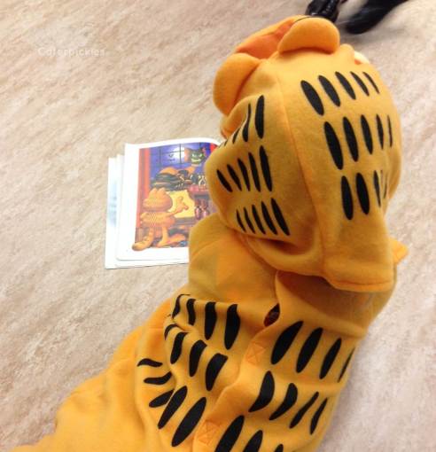 The Six-Year-Old camped out on the floor at school, waiting for the Halloween parade to start. Why yes, that is a Garfield book. (Photo: Shala Howell) 