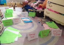 papers scattered across a bedroom floor. Some are propped up next to stuffed animals as if in a museum exhibit.