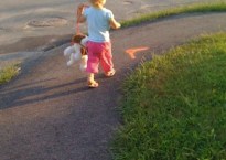 My daughter, then only two, takes her stuffed dog for a walk outside. The dog is hanging from a leash, lifted up just enough to keep from dragging on the ground.