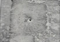 The medieval sundial looks like a hole in a stone wall surrounded by scratches in a circle at regular intervals.