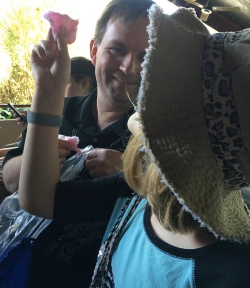 My daughter holds a piece of cotton candy up to the light. 