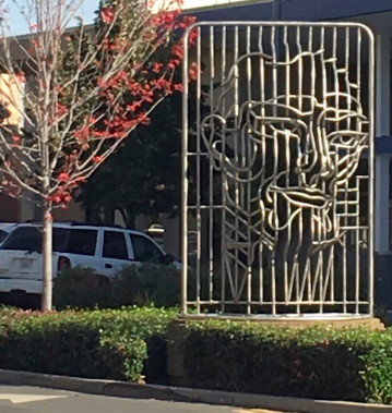 Fred Hunnicutt's aluminum sculpture imitates a face pushed through paper. The so-called paper in this case is actually a grid of aluminum tubes. 