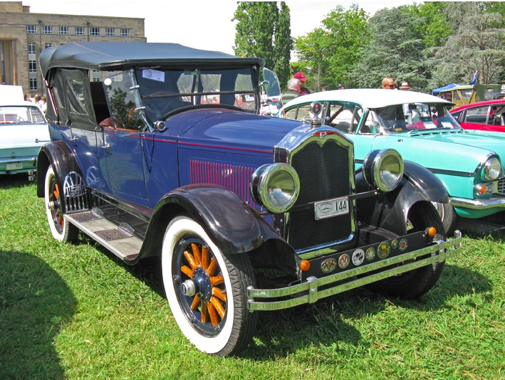A restored 1927 Buick Touring car with a canvas top and side curtains that look to be made of clear vinyl.