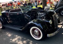 sleek black vintage convertible with white wall tires.
