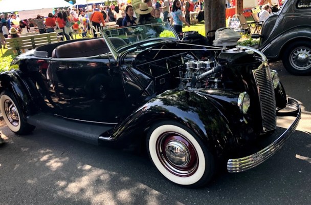 sleek black vintage convertible with white wall tires.