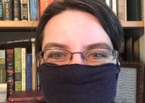 Photo of me wearing a no-sew mask made from one of my husband's old t-shirts.