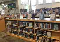 Photo of the interior of a middle school library, showing the fiction stacks.
