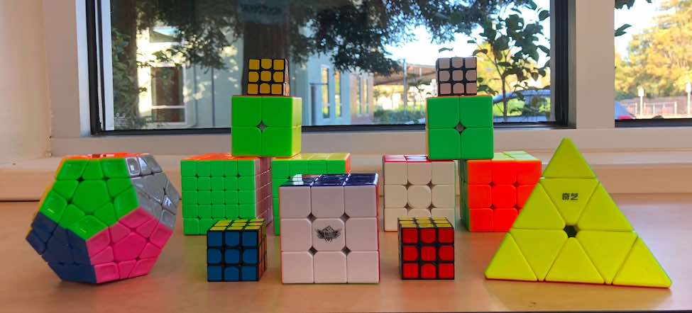 12 rubik's cubes: six 3x3s, two 2x2s, one 4x4, one 5x5, one pyramid, and one round one with 11 pieces on each side. 