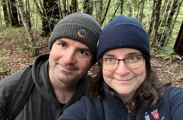 Image shows two smiling people paused for a selfie in a wooded area. My husband is wearing a knit winter cap with a Google logo on it. I'm wearing a Beth Israel Deaconness Medical Center fleece jacket that Michael got while he was practicing at Beth Israel.